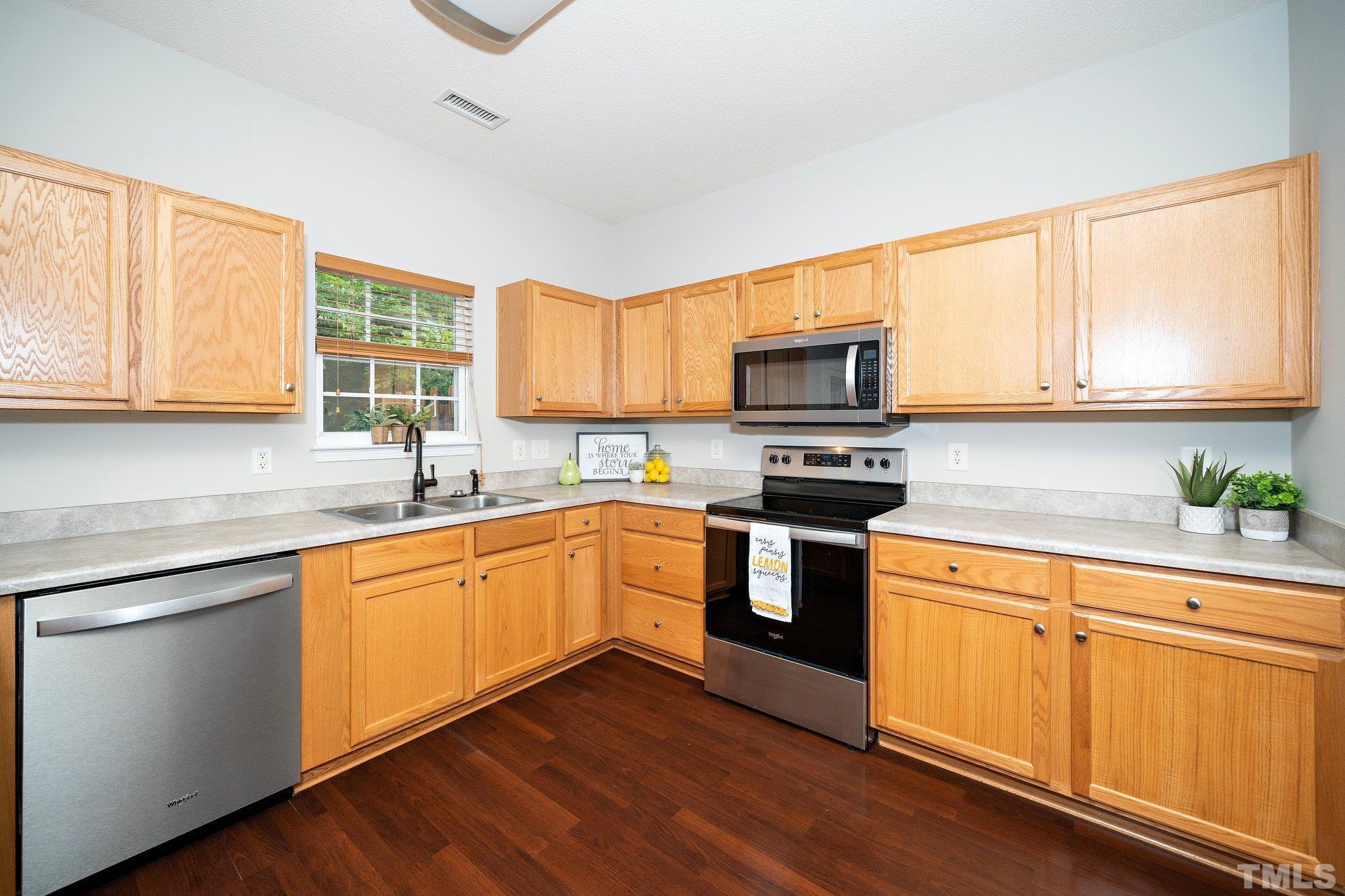 3121 Manhasset Lane Raleigh, NC 27604 - Photo 11 of 25 a kitchen with stainless steel appliances granite countertop a stove a sink and a microwave