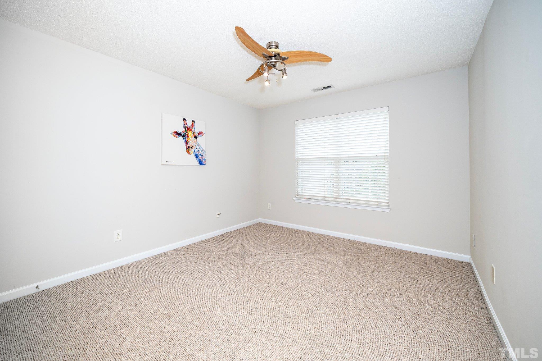 3121 Manhasset Lane Raleigh, NC 27604 - Photo 18 of 25 an empty room with a ceiling fan and window