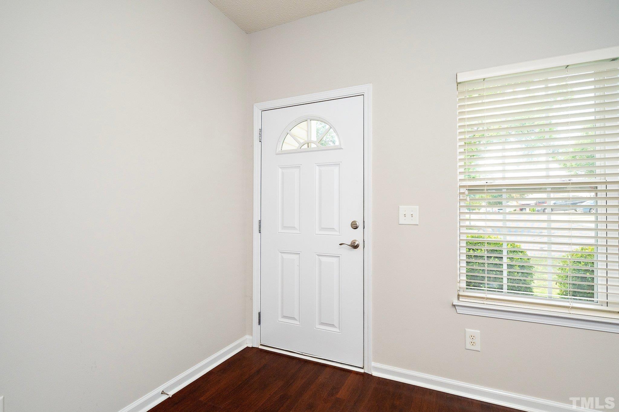 3121 Manhasset Lane Raleigh, NC 27604 - Photo 5 of 25 a view of an empty room with wooden floor and a window