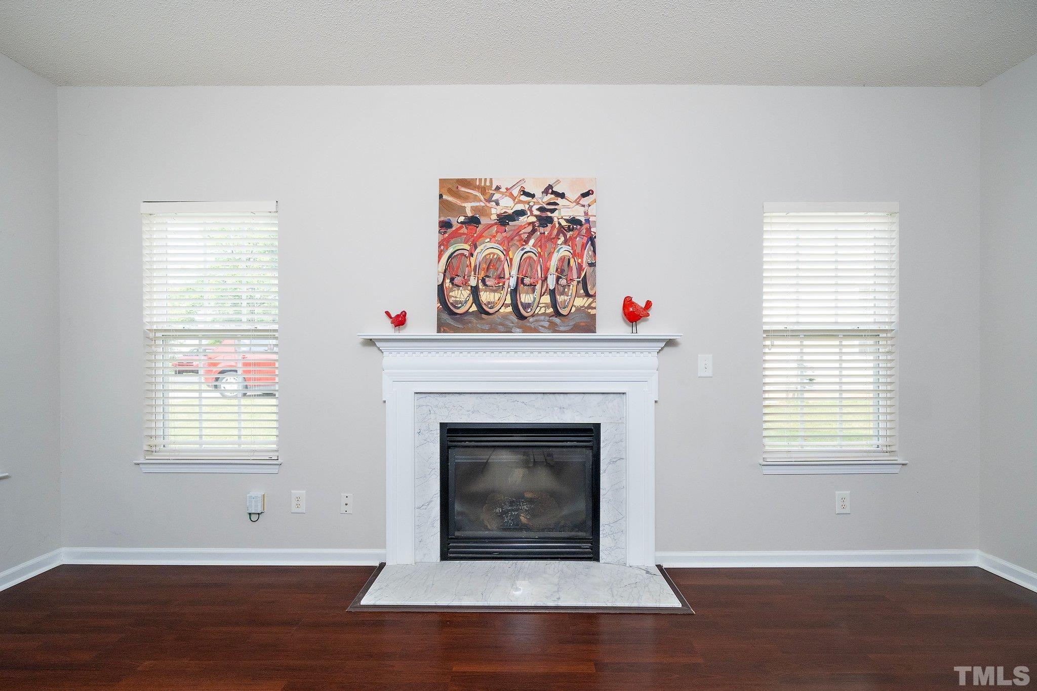 3121 Manhasset Lane Raleigh, NC 27604 - Photo 7 of 25 a living room with a fireplace and wooden floor