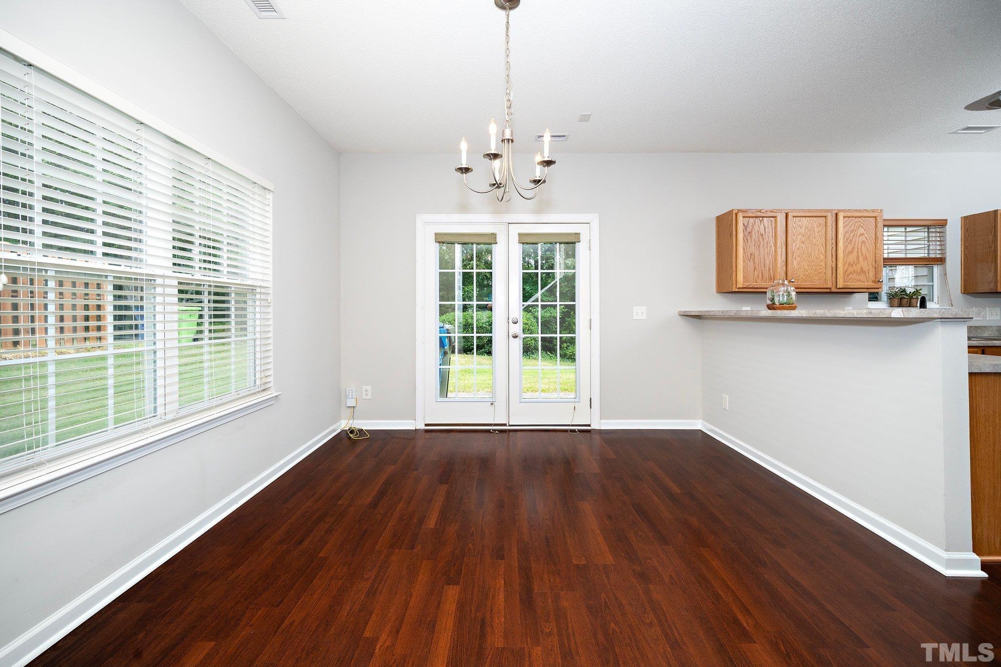 3121 Manhasset Lane Raleigh, NC 27604 - Photo 9 of 25 a view of an empty room with a window and wooden floor