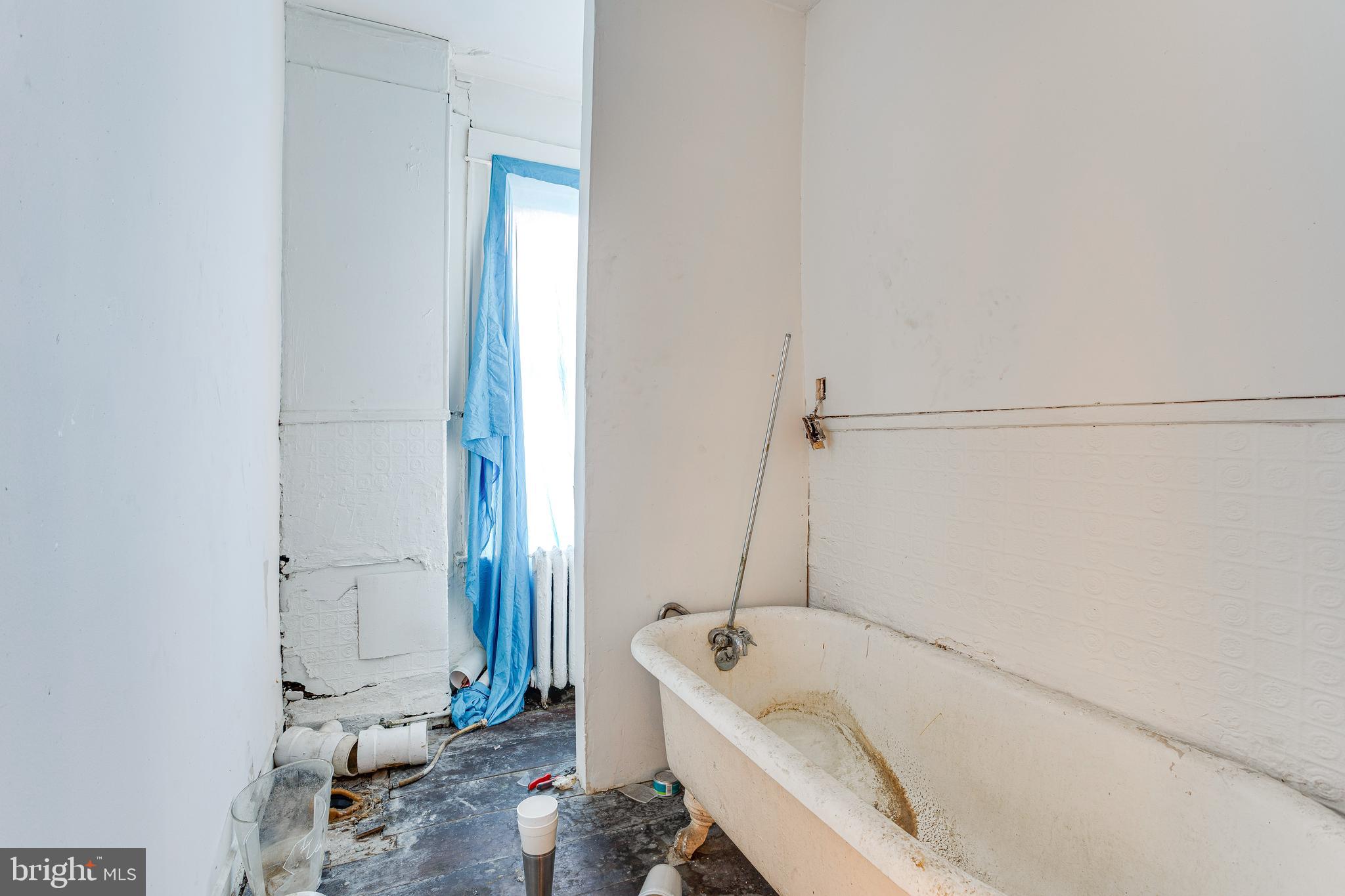 5109 Chester Avenue Philadelphia, PA 19143 - Photo 28 of 34 a bathroom with a tub a sink and a window