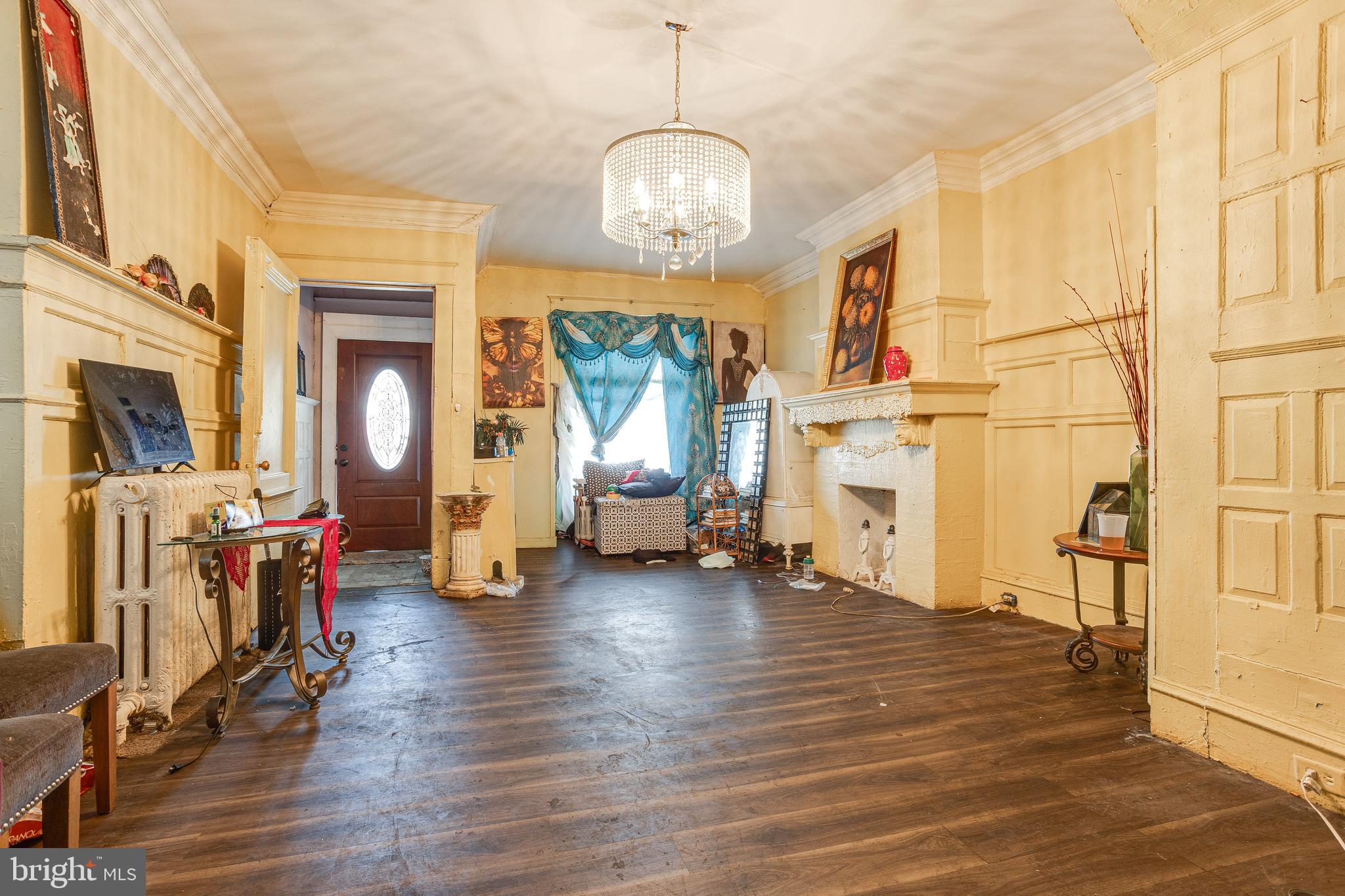 5109 Chester Avenue Philadelphia, PA 19143 - Photo 10 of 34 a view of a livingroom with furniture a fireplace wooden floor and windows