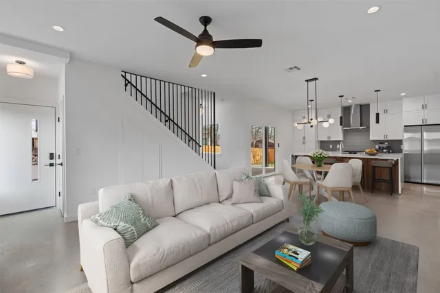 a living room with furniture kitchen view and a chandelier