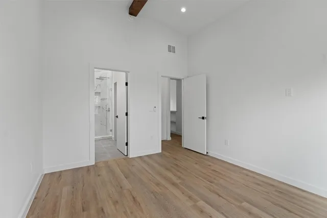 a view of an empty room with wooden floor