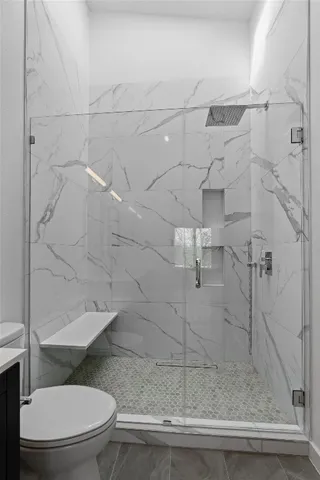 a bathroom with a toilet and a shower