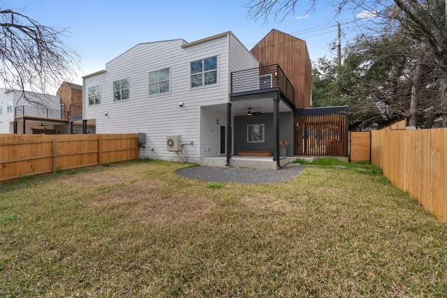 a view of a house with backyard and a tree