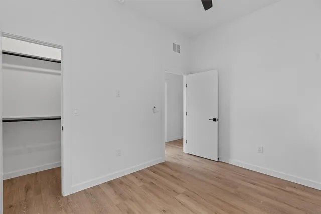 a view of an empty room with wooden floor