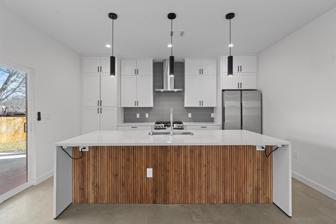 5601 Manor Road, Unit A Austin, TX 78723 - Photo 3 of 35 a large kitchen with kitchen island a stove a sink a center island and windows