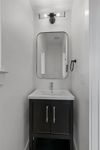 a bathroom with a granite countertop sink a mirror and vanity