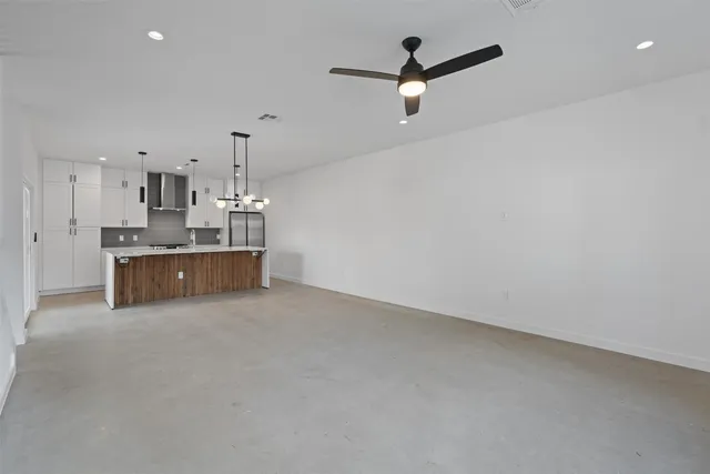 a large kitchen with stainless steel appliances a large counter top a stove a chimney a sink and a refrigerator