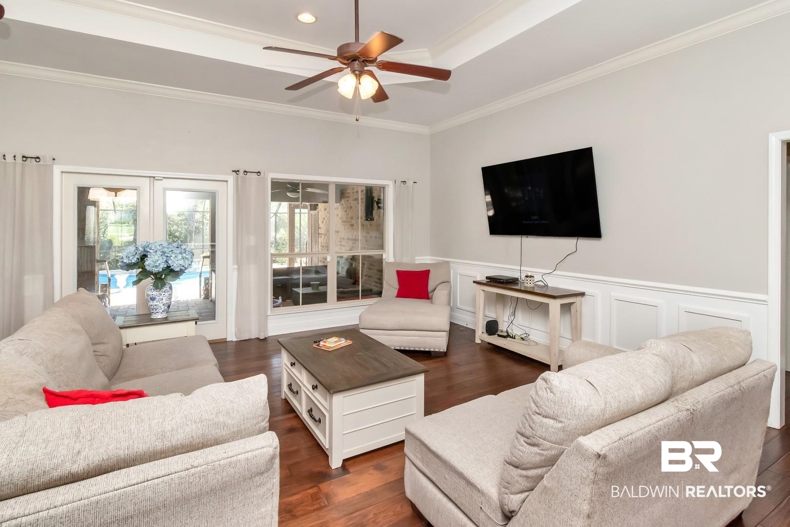 27890 Rileywood Drive Daphne, AL 36526 - Photo 11 of 49 Living room featuring dark wood finished floors, a ceiling fan, ornamental molding, and a wainscoted wall