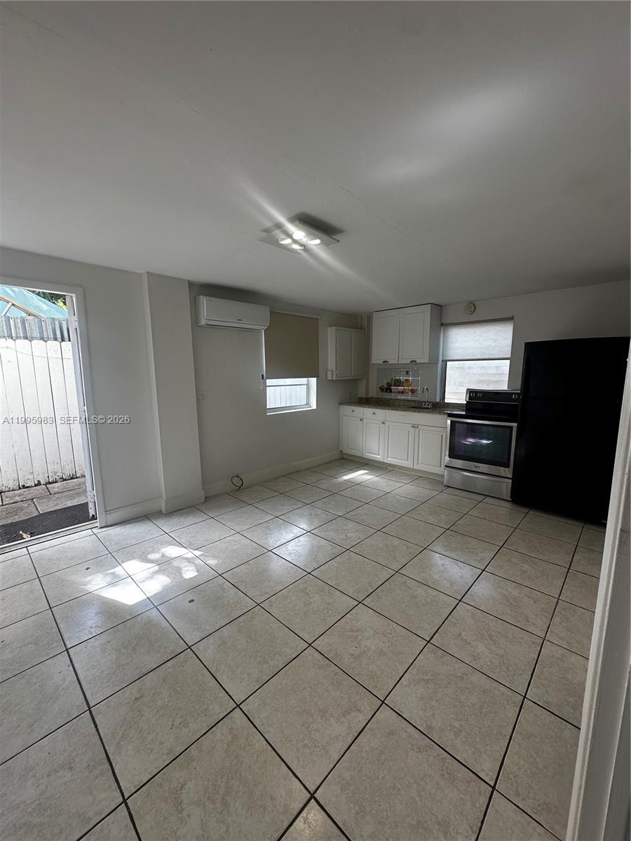 2420 Southwest 34th Avenue, Unit A Miami, FL 33145 - Photo 11 of 15 a kitchen with stainless steel appliances granite countertop a refrigerator and a stove top oven