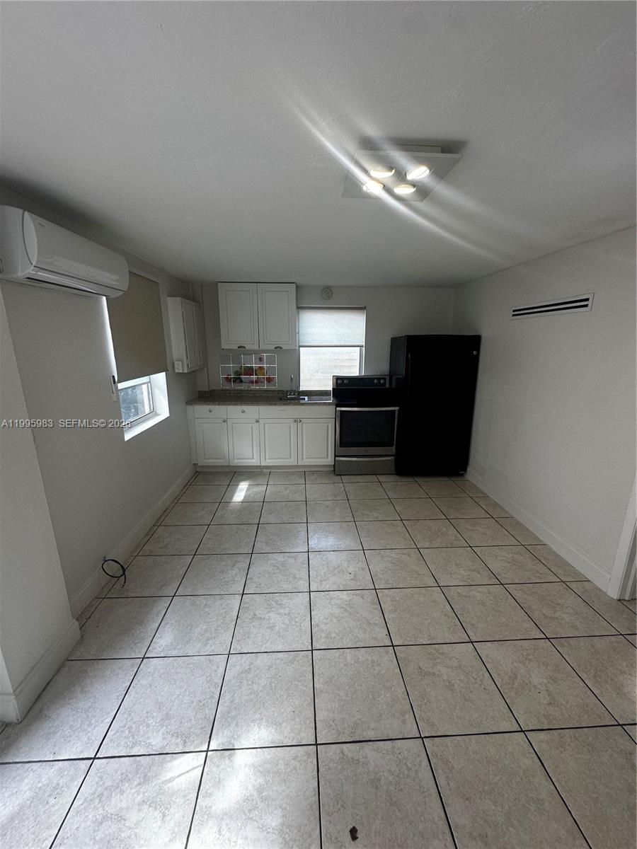 2420 Southwest 34th Avenue, Unit A Miami, FL 33145 - Photo 12 of 15 a view of a refrigerator in kitchen and wooden cabinets