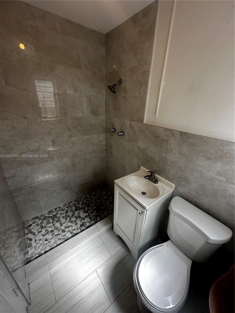 2420 Southwest 34th Avenue, Unit A Miami, FL 33145 - Photo 8 of 15 a white toilet sitting next to a bath tub
