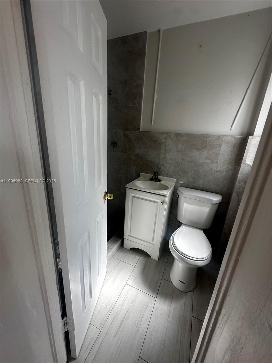 2420 Southwest 34th Avenue, Unit A Miami, FL 33145 - Photo 9 of 15 a white toilet sitting next to a sink