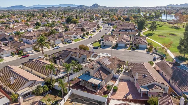 an aerial view of a house with a mountain