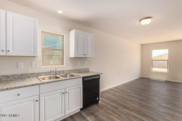 a kitchen with a sink window and cabinets