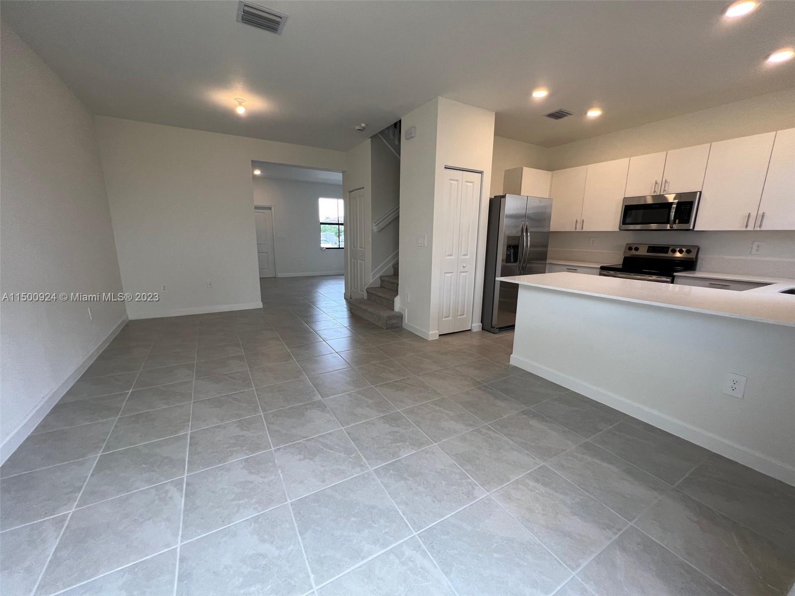 11743 Southwest 246th Terrace, Unit 11743 Homestead, FL 33032 - Photo 3 of 10 a view of kitchen with stainless steel appliances a refrigerator and a stove top oven
