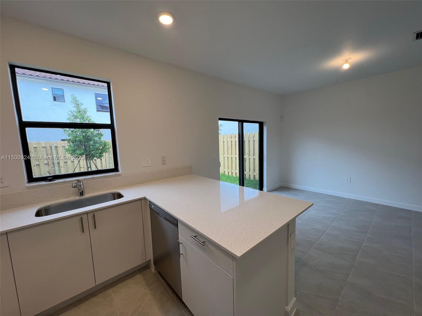 11743 Southwest 246th Terrace, Unit 11743 Homestead, FL 33032 - Photo 5 of 10 a view of kitchen with granite countertop cabinets and sink