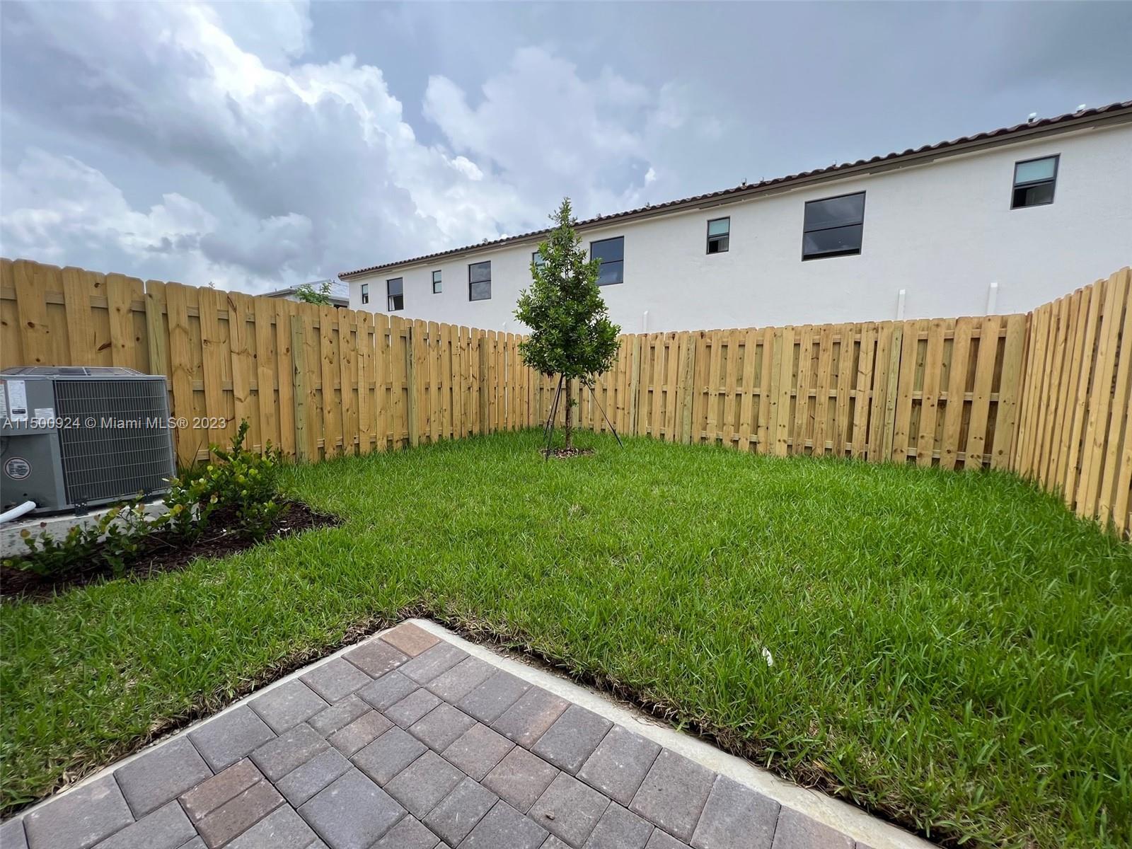 11743 Southwest 246th Terrace, Unit 11743 Homestead, FL 33032 - Photo 6 of 10 a backyard of a house with lots of green space and plants