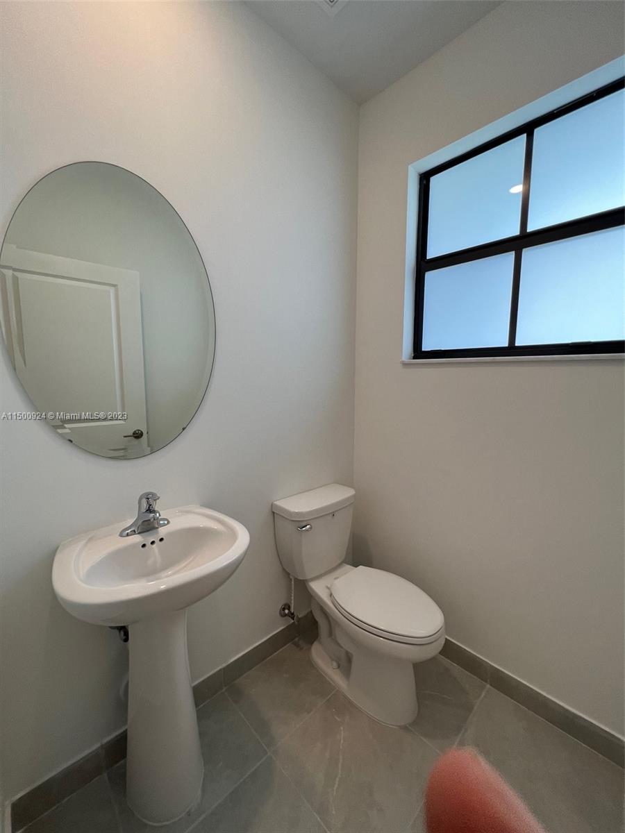 11743 Southwest 246th Terrace, Unit 11743 Homestead, FL 33032 - Photo 8 of 10 a bathroom with a toilet sink and mirror
