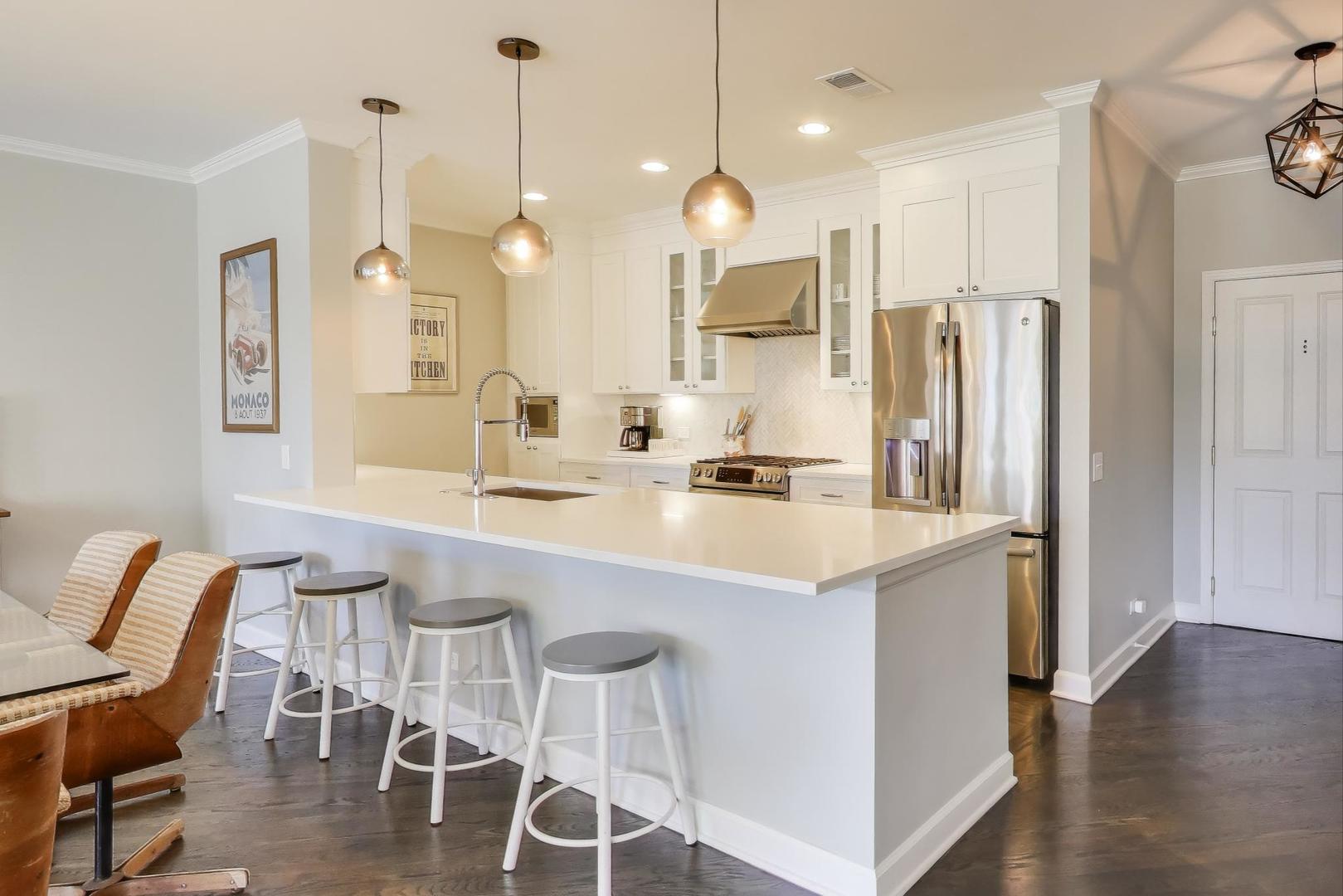 1414 North Wells Street, Unit 405 Chicago, IL 60610 - Photo 8 of 27 a kitchen with stainless steel appliances kitchen island granite countertop a table chairs and a sink