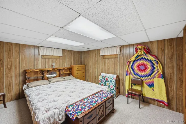 a bedroom with a large bed and wooden floor