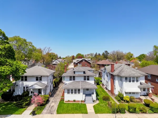 a view of a big house with a big yard and potted plants