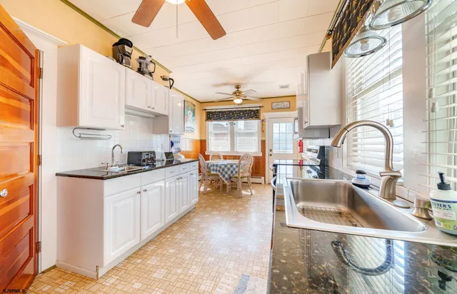 a kitchen with granite countertop a sink and a stove top oven