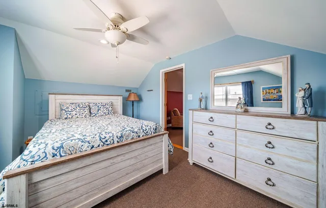 a bedroom with a large bed and a mirror on dresser