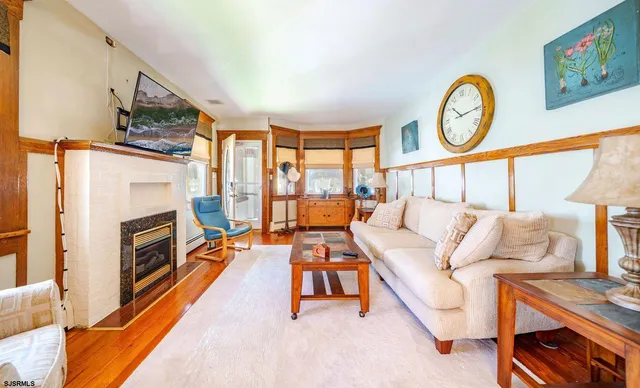 a living room with furniture a fireplace and a large window
