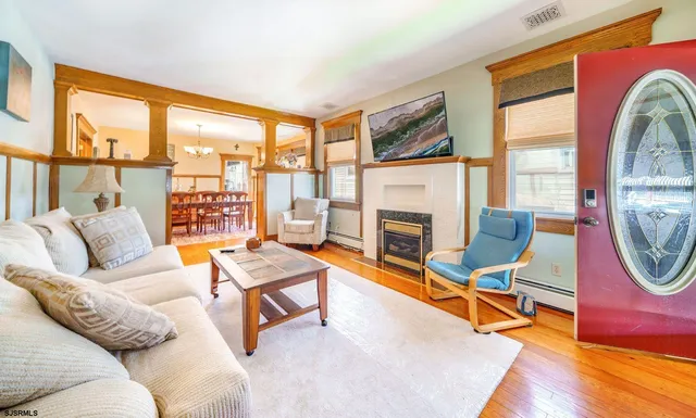 a living room with furniture a fireplace and a floor to ceiling window