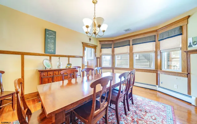 a dining room with furniture a chandelier and wooden floor