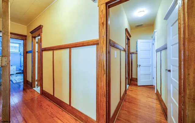 a view of a hallway with wooden floor and staircase