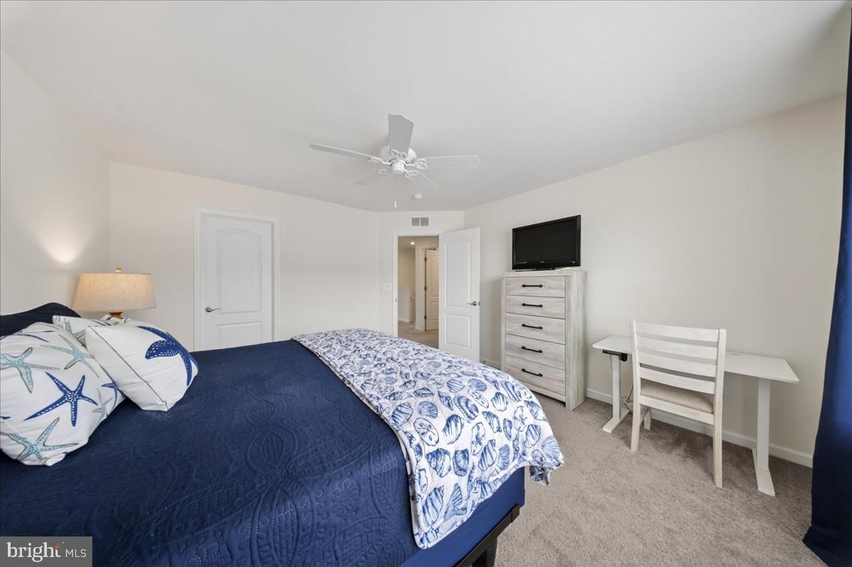 38023 Cross Gate Road Millville, DE 19967 - Photo 21 of 37 a bedroom with a bed a chandelier and a flat screen tv