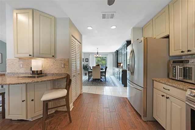 a kitchen with a refrigerator a sink and wooden cabinets
