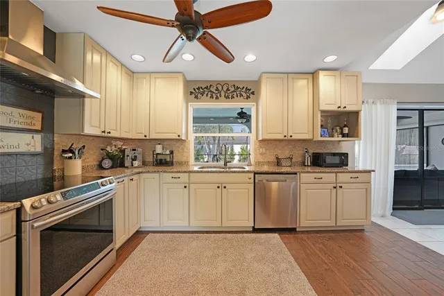 a kitchen with white cabinets stainless steel appliances and window