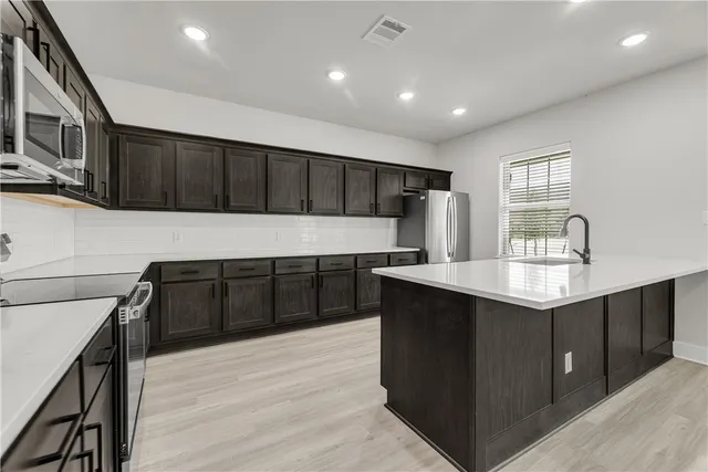 a kitchen with stainless steel appliances granite countertop a sink stove and refrigerator