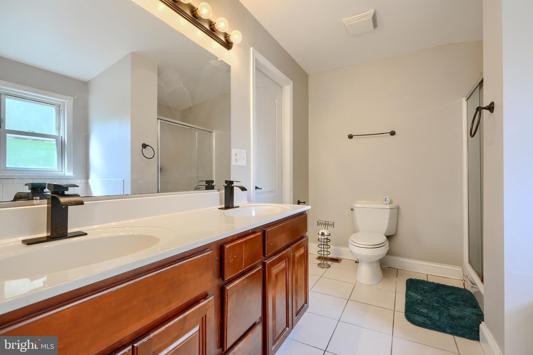 5221 Trumps Mill Road Baltimore, MD 21206 - Photo 31 of 53 a bathroom with a sink a toilet and a mirror