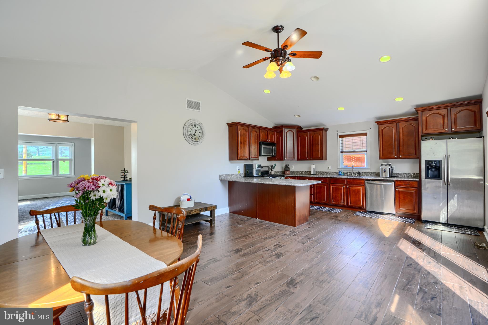 5221 Trumps Mill Road Baltimore, MD 21206 - Photo 5 of 53 a kitchen with stainless steel appliances kitchen island granite countertop a sink dishwasher and a dining table with wooden floor