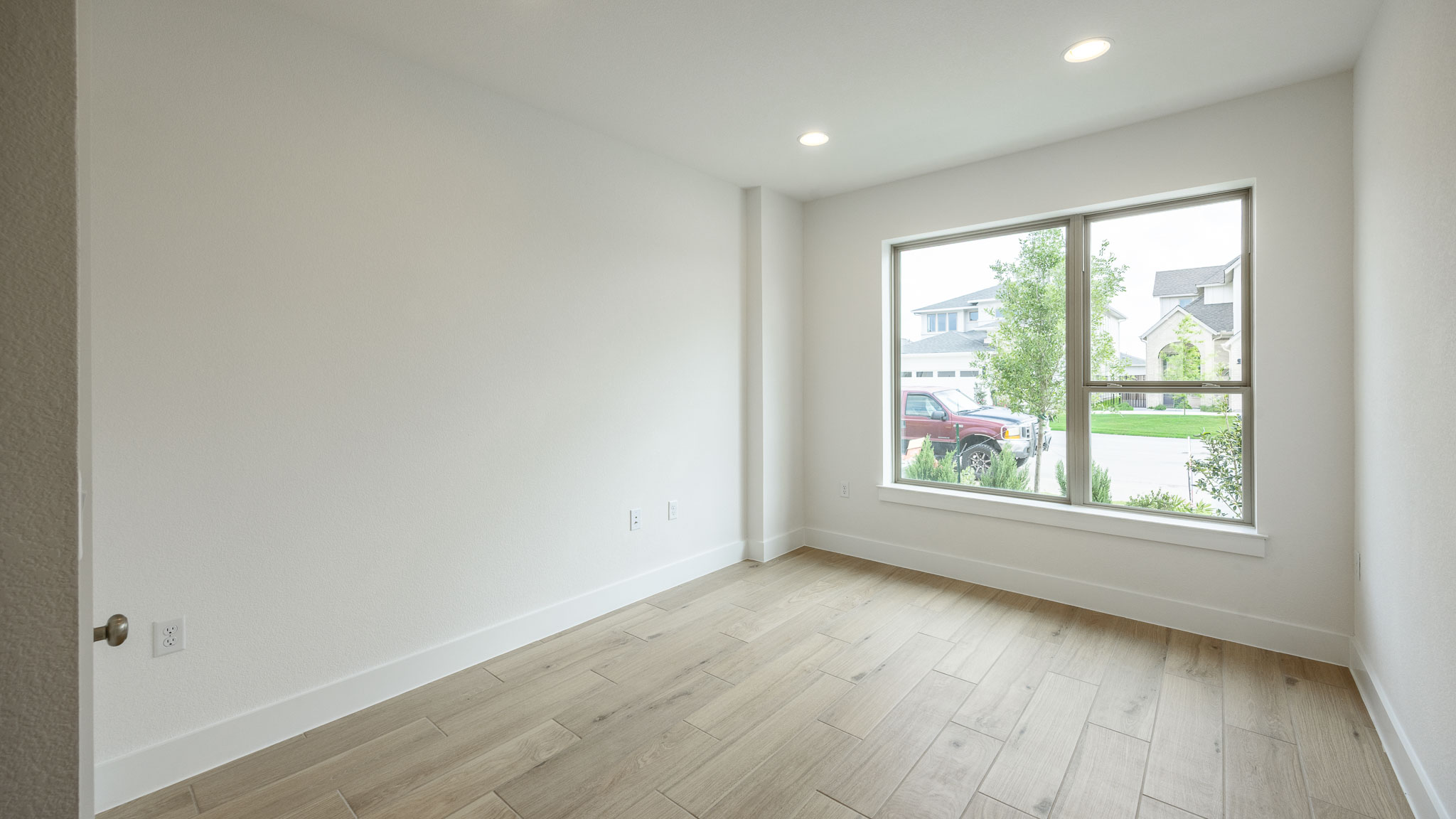 7002 Woodford Way Austin, TX 78744 - Photo 9 of 22 an empty room with wooden floor and windows