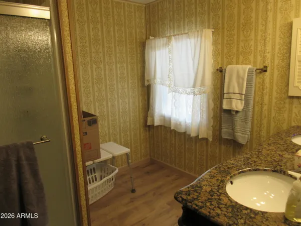 a bathroom with a granite countertop sink a mirror and a shower