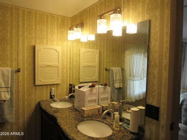 a bathroom with double vanity and a mirror