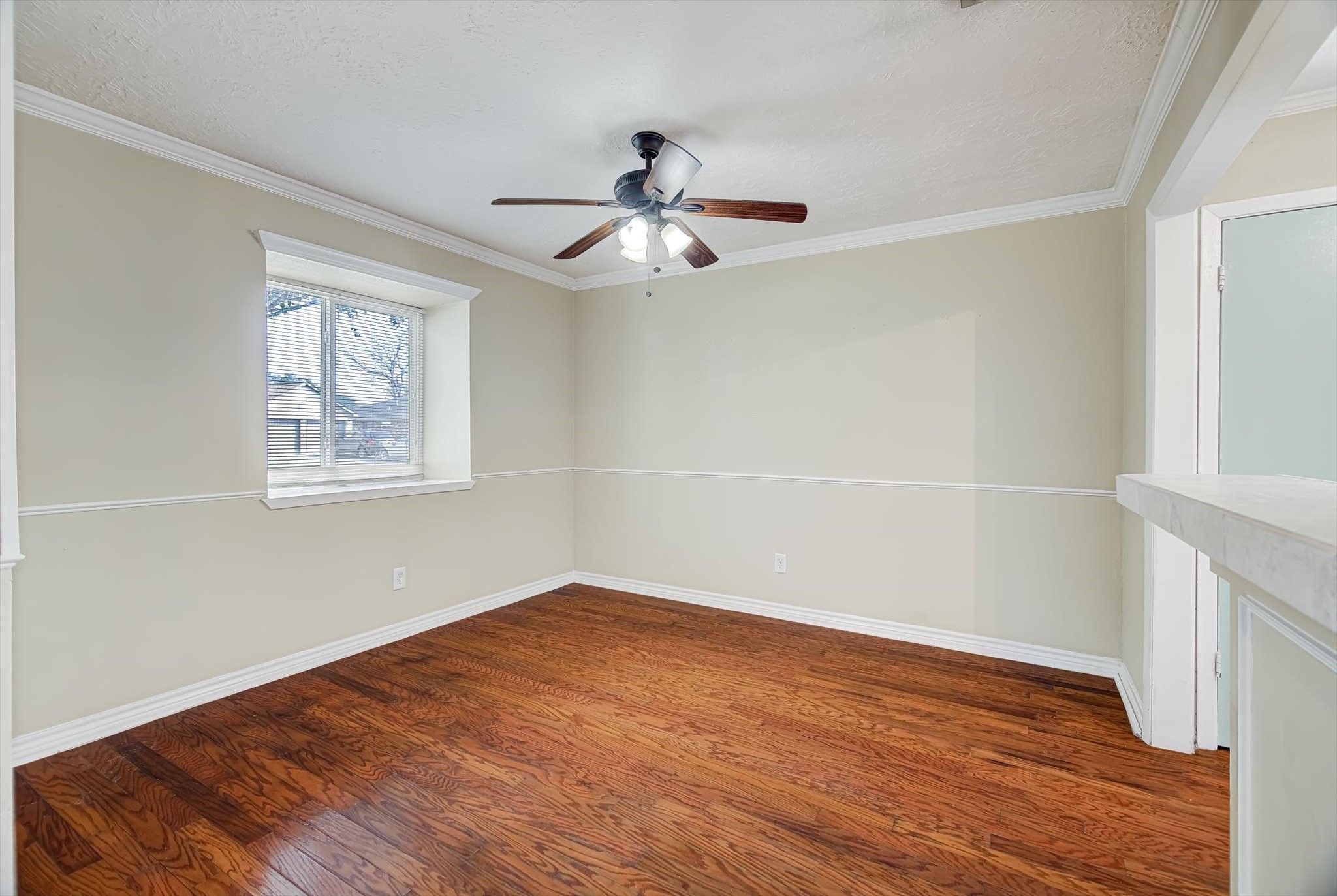 7515 Shoshone Drive Baytown, TX 77521 - Photo 6 of 39 an empty room with wooden floor ceiling fan and windows