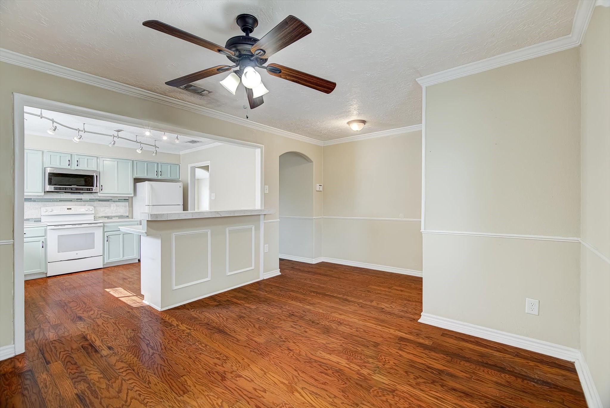 7515 Shoshone Drive Baytown, TX 77521 - Photo 8 of 39 a view of a kitchen with wooden floor and a ceiling fan