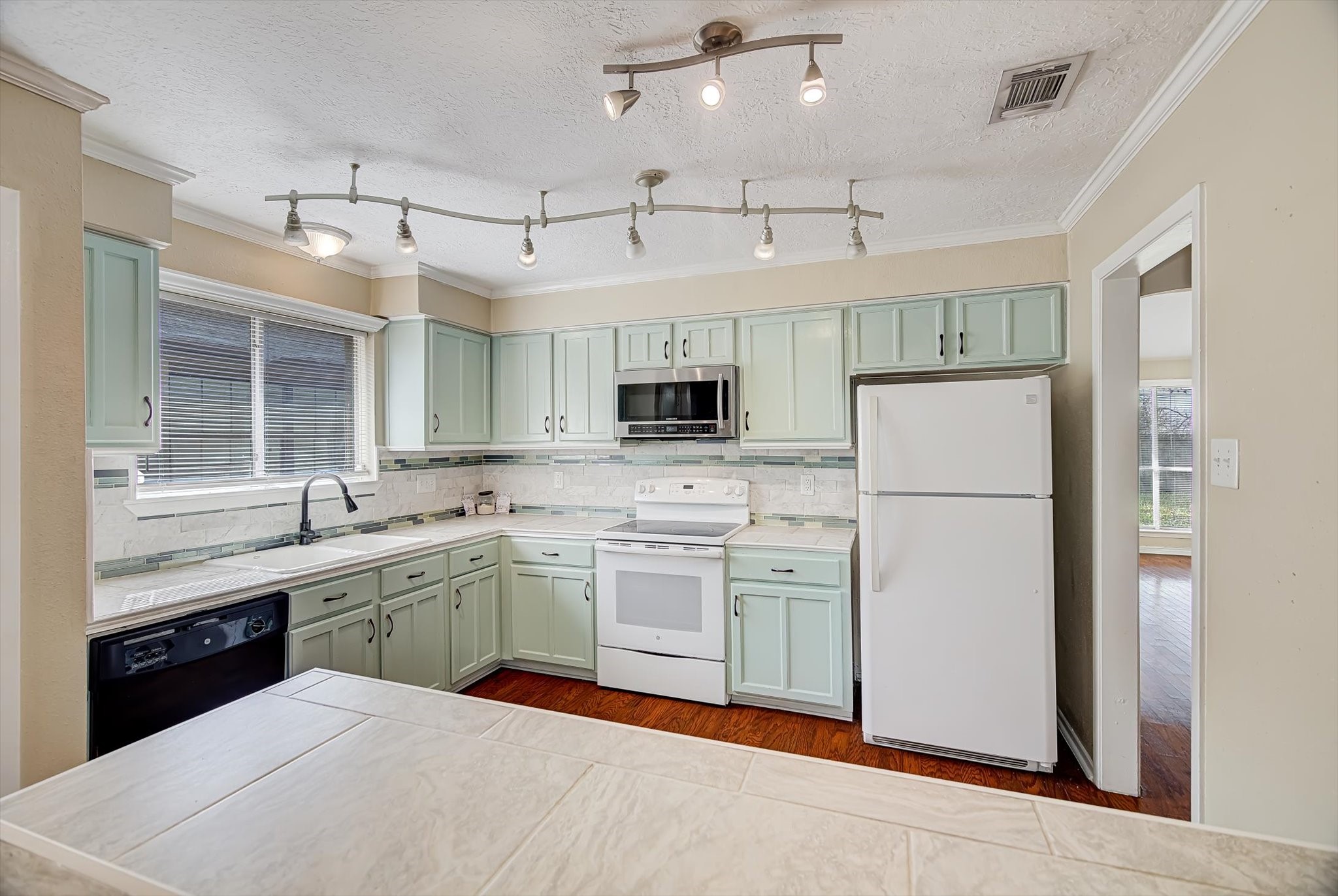 7515 Shoshone Drive Baytown, TX 77521 - Photo 10 of 39 a kitchen with stainless steel appliances granite countertop a refrigerator a sink dishwasher a oven with white cabinets and wooden floor