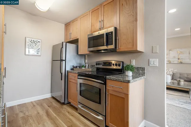 a kitchen with stainless steel appliances granite countertop a stove a microwave and a refrigerator