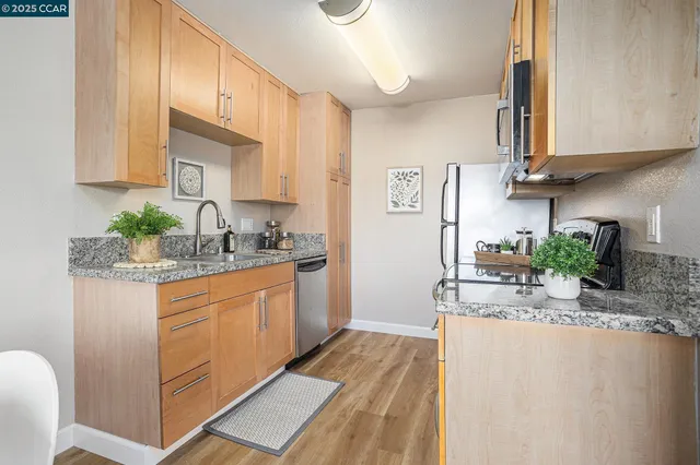 a kitchen with stainless steel appliances granite countertop a sink and a refrigerator