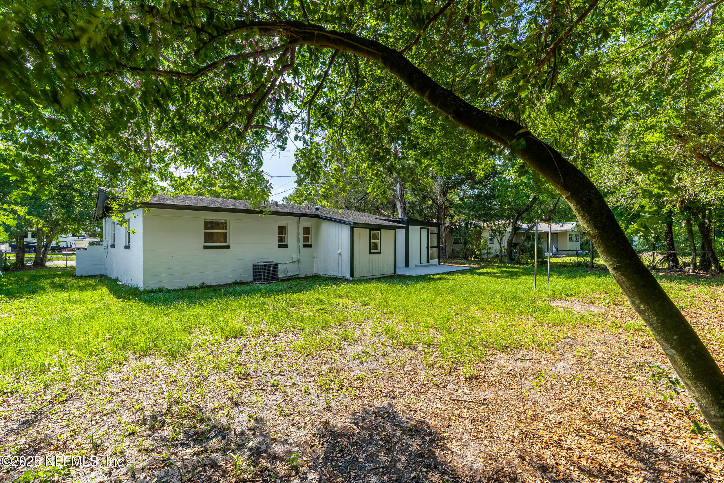 3903 Macgregor Drive Jacksonville, FL 32210 - Photo 36 of 49 a backyard of a house with plants and large tree